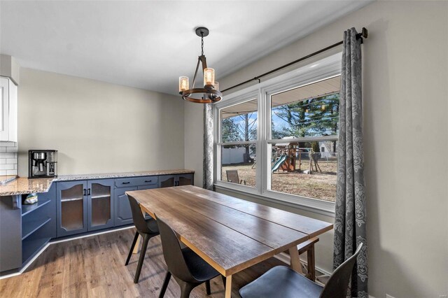 dining area featuring wood-type flooring and a chandelier