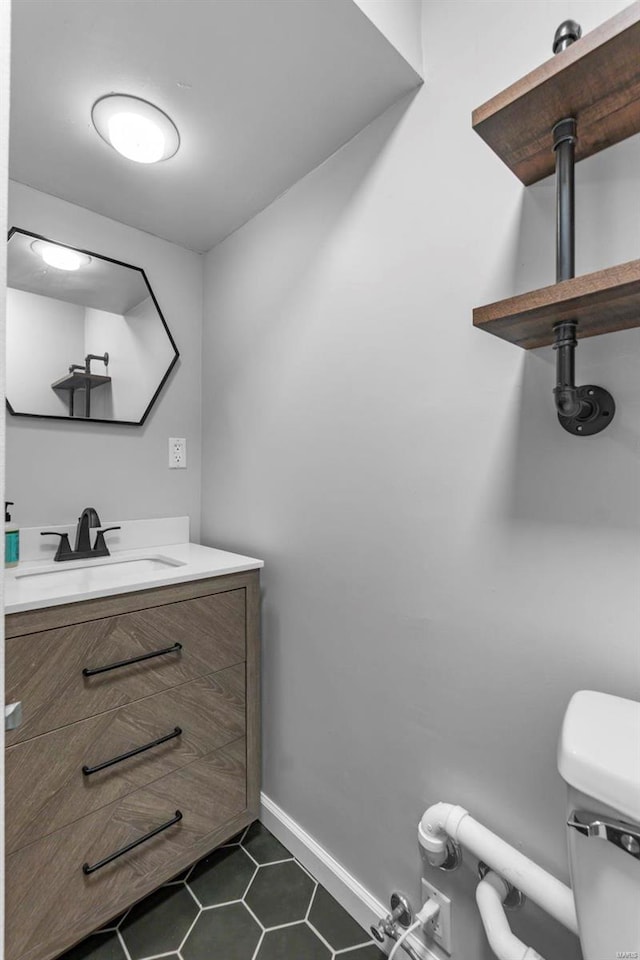 bathroom featuring tile patterned flooring, vanity, and toilet