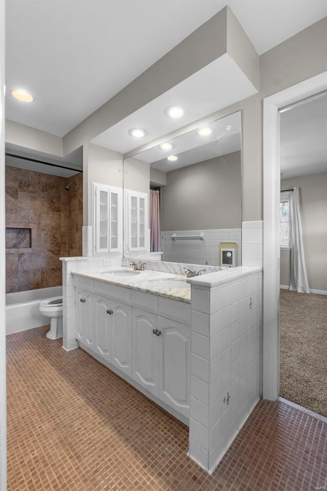 full bathroom featuring vanity, tiled shower / bath combo, and toilet