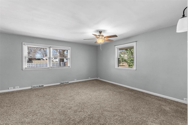 carpeted empty room featuring a healthy amount of sunlight and ceiling fan