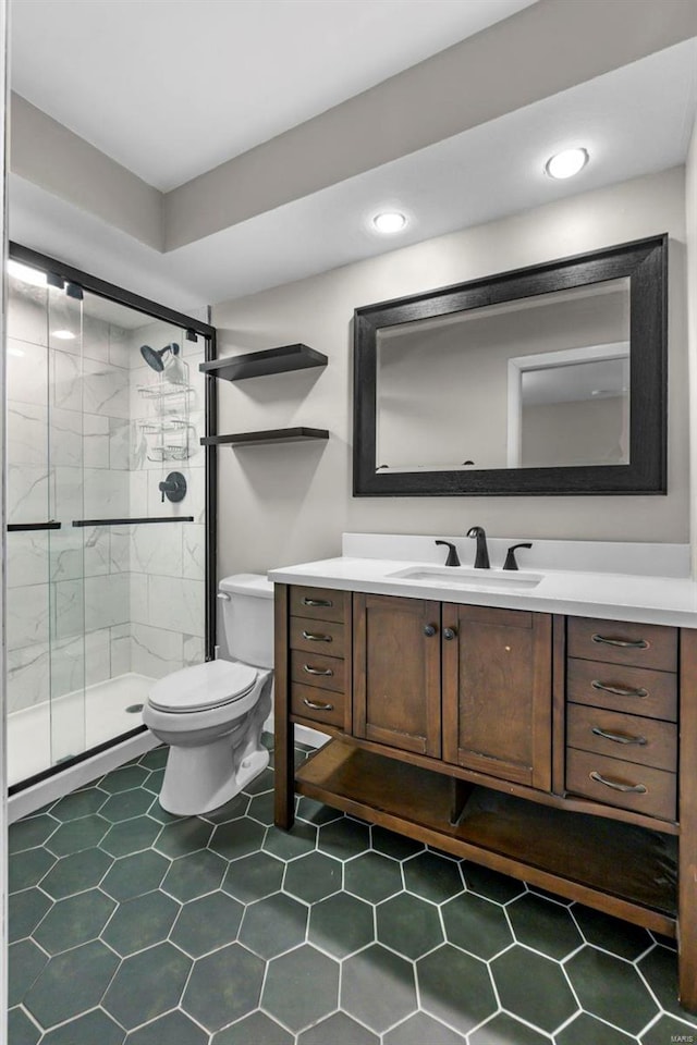 bathroom featuring vanity, toilet, and a shower with shower door