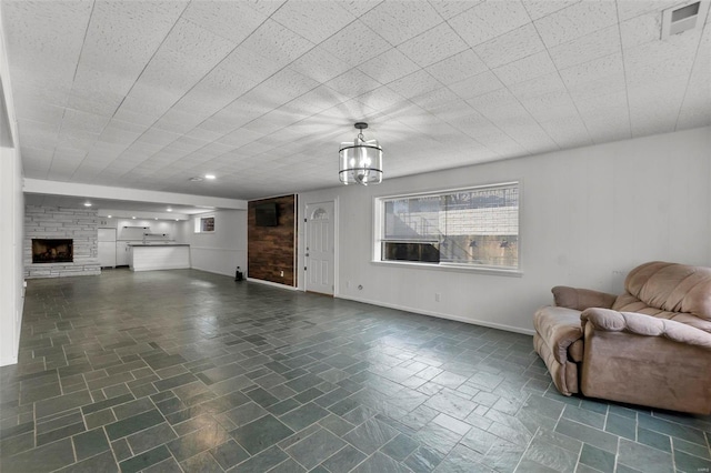 unfurnished living room with a fireplace and a chandelier