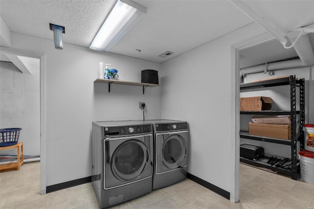 clothes washing area featuring separate washer and dryer and a textured ceiling