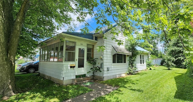 rear view of property featuring a lawn