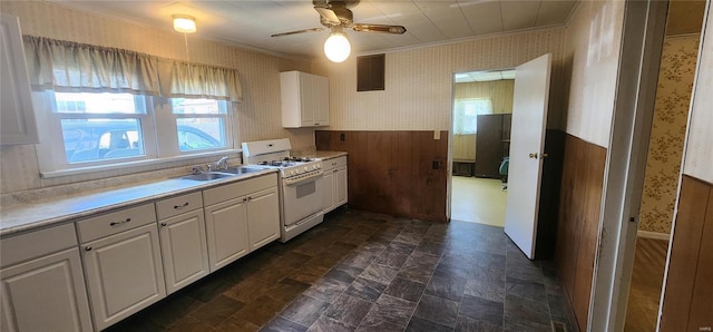 kitchen with gas range gas stove, white cabinets, dark tile floors, ceiling fan, and sink