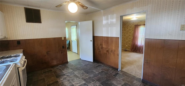 kitchen with dark tile flooring, ceiling fan, white cabinets, and white gas stove