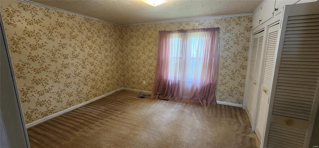 carpeted spare room featuring crown molding