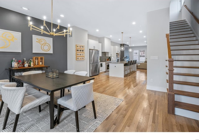 dining space featuring light wood-type flooring and a chandelier