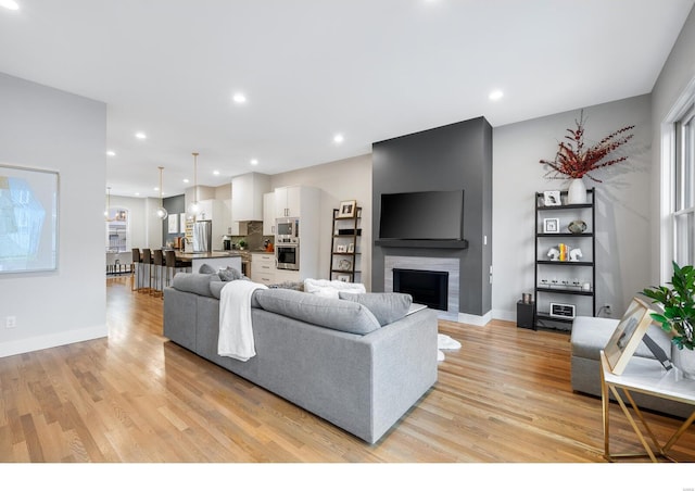 living room with light wood-type flooring and a fireplace