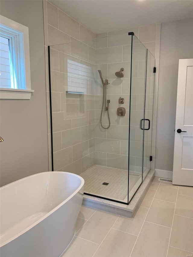 bathroom featuring plus walk in shower and tile patterned floors