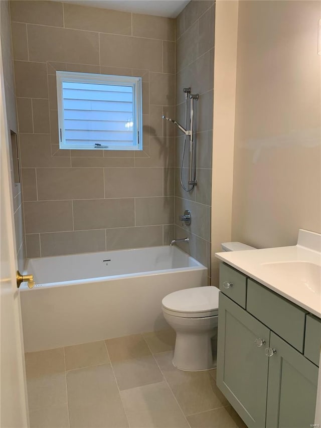 full bathroom with tile patterned floors, vanity, tiled shower / bath combo, and toilet