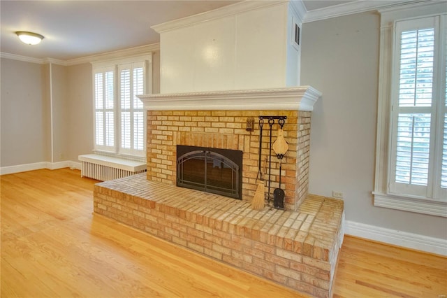 interior details with ornamental molding, radiator heating unit, a fireplace, and hardwood / wood-style floors