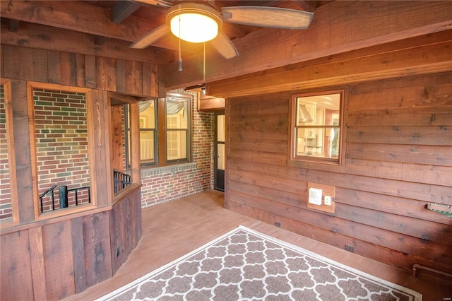 unfurnished room featuring ceiling fan, brick wall, and wooden walls