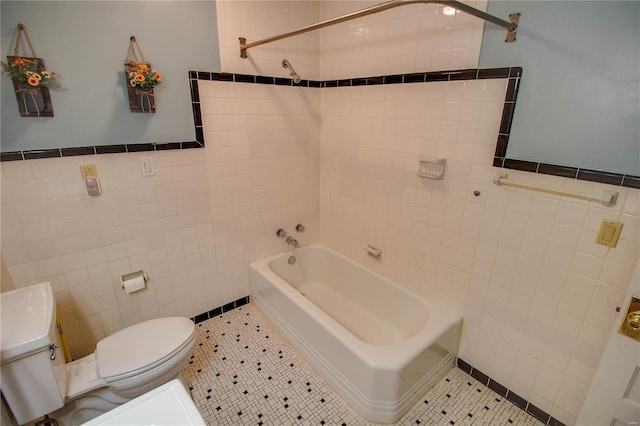 bathroom featuring toilet, tile patterned flooring, and tile walls