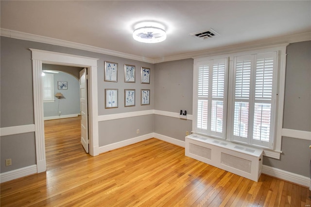 unfurnished room with radiator heating unit, crown molding, and light hardwood / wood-style flooring