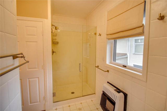 bathroom featuring heating unit, an enclosed shower, tile patterned flooring, and tile walls