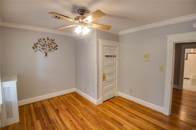 empty room featuring ceiling fan, ornamental molding, and hardwood / wood-style floors