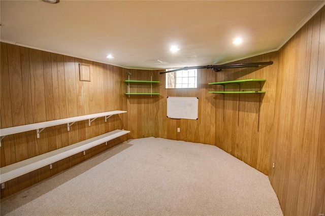 basement featuring crown molding, carpet flooring, and wooden walls