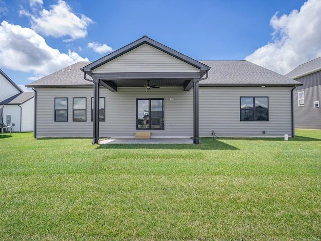 rear view of property featuring ceiling fan, a yard, and a patio