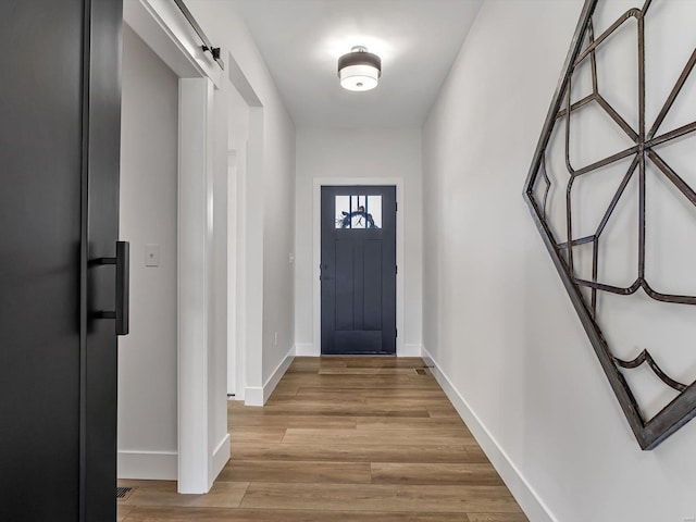 doorway with a barn door and light hardwood / wood-style flooring