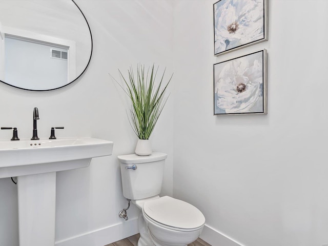 bathroom featuring sink, hardwood / wood-style floors, and toilet