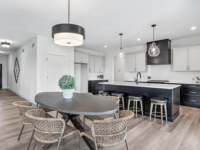 dining room with sink and light wood-type flooring