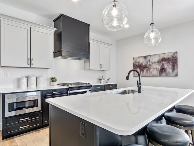 kitchen featuring pendant lighting, sink, and an island with sink