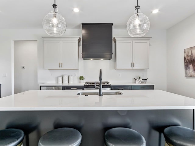 kitchen featuring decorative light fixtures, gray cabinets, and wall chimney exhaust hood