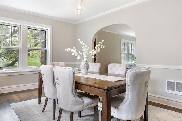 dining room featuring ornamental molding, wood-type flooring, and a wealth of natural light