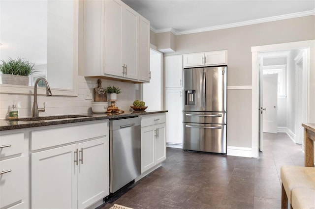 kitchen with dark stone countertops, white cabinets, stainless steel appliances, dark tile patterned flooring, and decorative backsplash