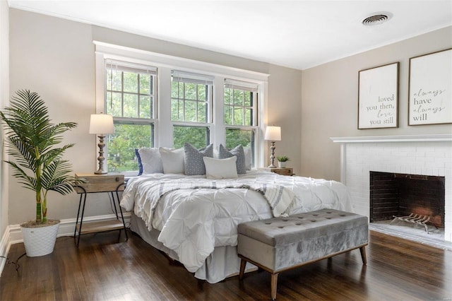 bedroom featuring a fireplace and dark hardwood / wood-style floors