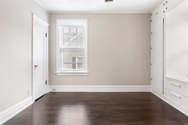 unfurnished room with dark wood-type flooring and ornamental molding