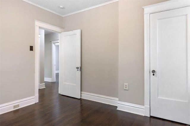 empty room featuring dark wood-type flooring, crown molding, and a textured ceiling