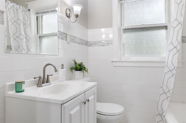 full bathroom featuring shower / tub combo, vanity, toilet, and tile walls