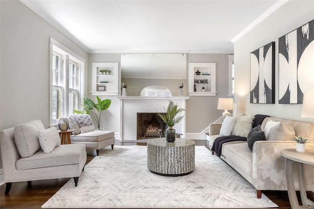 living room featuring ornamental molding, hardwood / wood-style flooring, a brick fireplace, and built in shelves