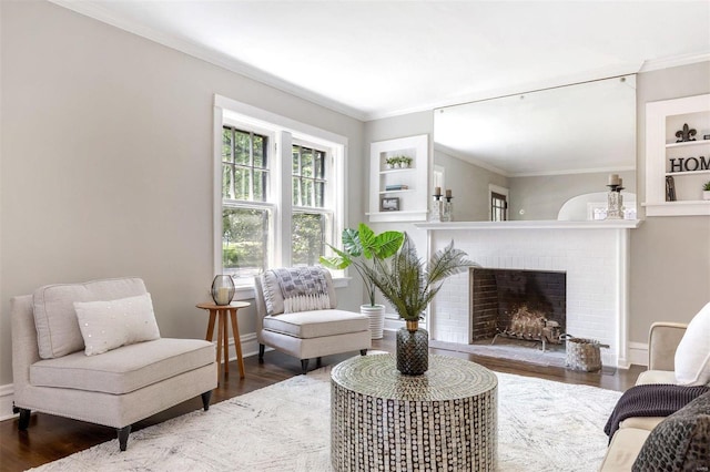 living room with built in features, crown molding, dark hardwood / wood-style floors, and a brick fireplace