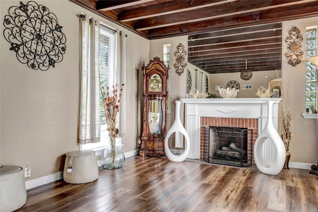 living room featuring beam ceiling, a brick fireplace, wood ceiling, and hardwood / wood-style floors