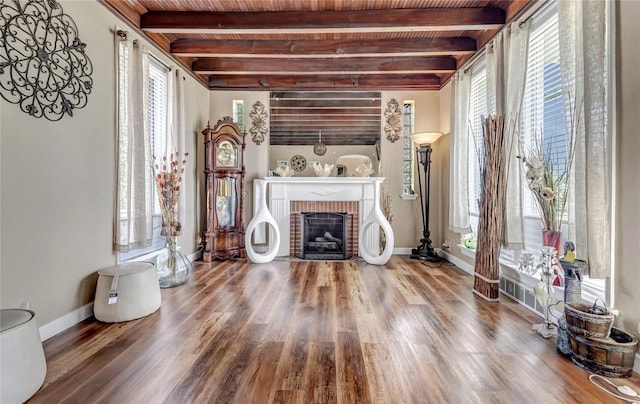 living room featuring beam ceiling, a fireplace, and a wealth of natural light