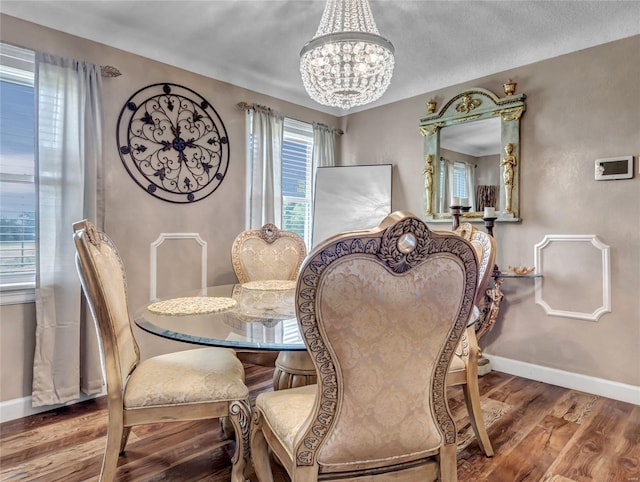 dining space with hardwood / wood-style floors and an inviting chandelier