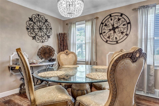 dining space with dark wood-type flooring and a notable chandelier