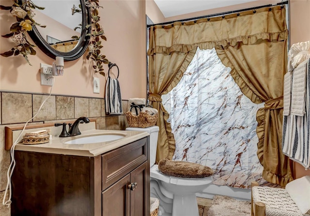 bathroom featuring vanity, toilet, and tile walls