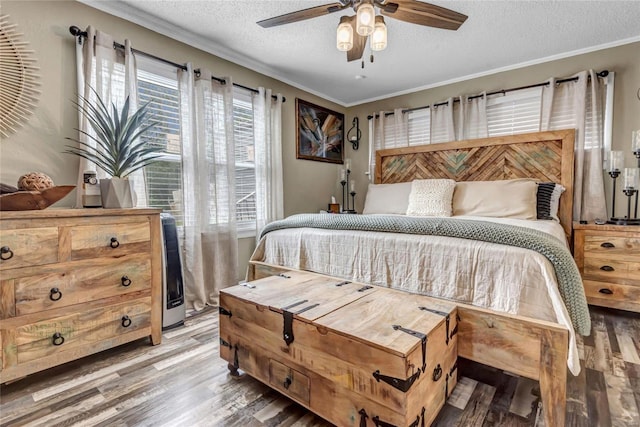 bedroom with hardwood / wood-style floors, ceiling fan, crown molding, and a textured ceiling