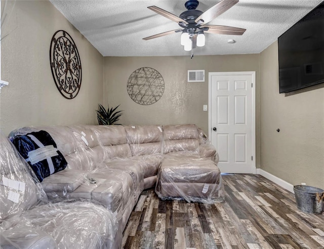 living room featuring hardwood / wood-style floors, a textured ceiling, and ceiling fan