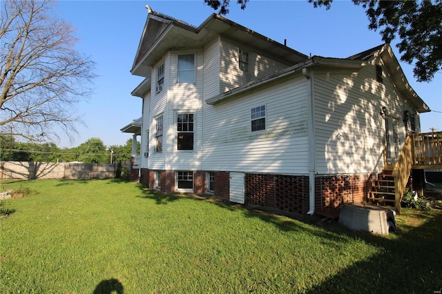 view of side of home featuring a deck and a lawn