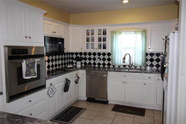 kitchen with sink, tasteful backsplash, light tile floors, and stainless steel appliances