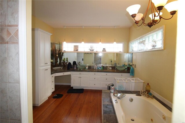 bathroom featuring a washtub, wood-type flooring, a chandelier, and vanity