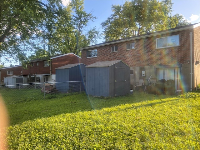 rear view of house featuring a shed and a lawn