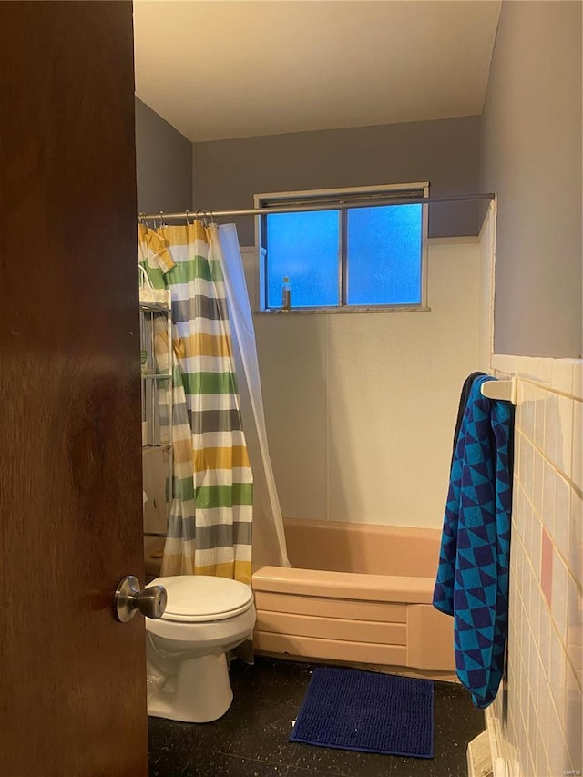 bathroom featuring toilet, tile walls, and shower / bath combo with shower curtain