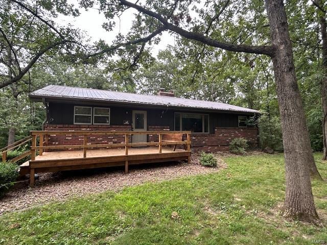 back of property featuring a yard and a deck