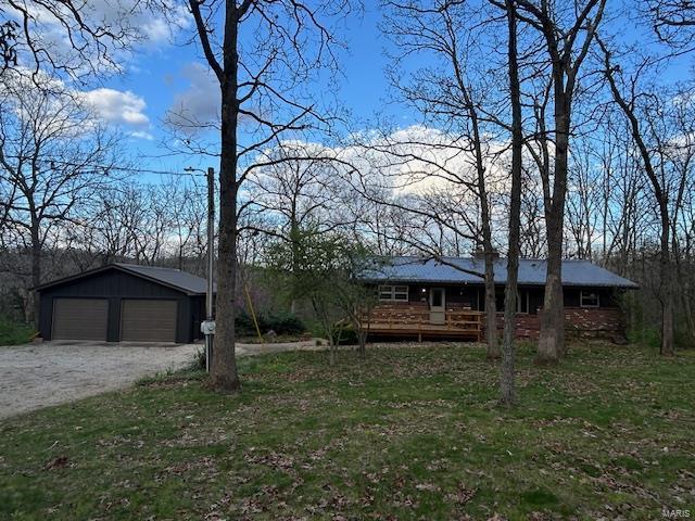 single story home featuring an outbuilding and a garage